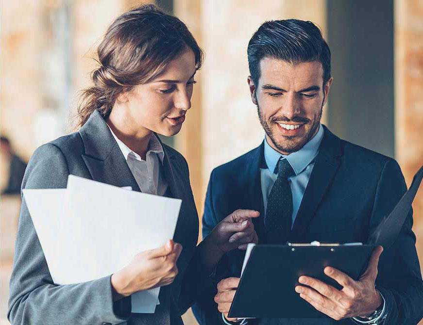 two professionals examine a document